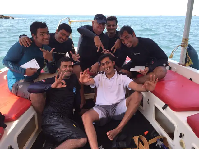 Hardik with a group of dive candidates and an instructor on a boat, all signalling OK